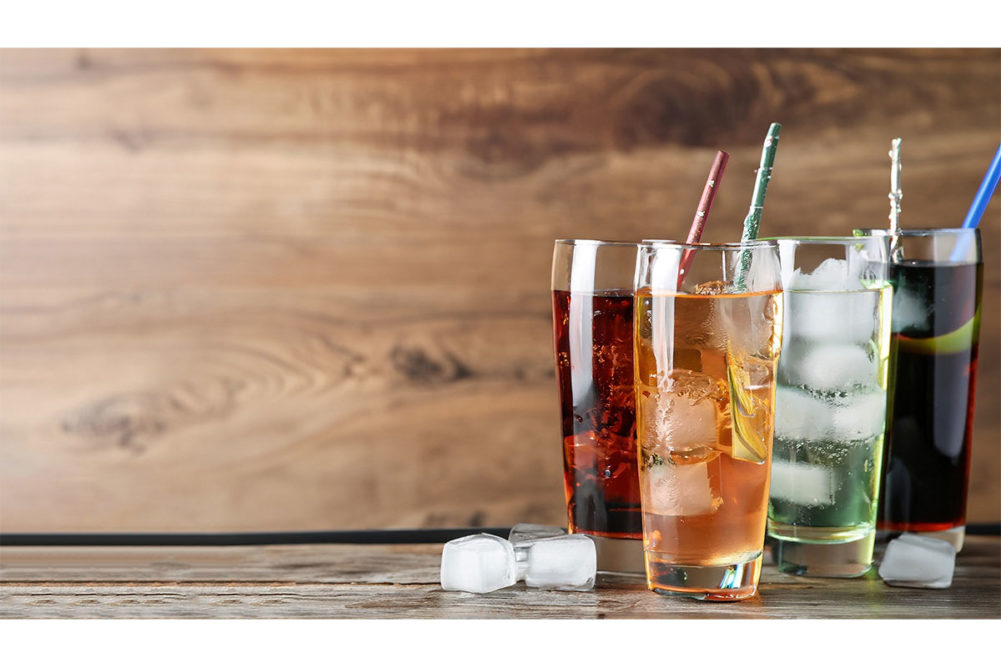 Glasses of different soda with ice in them