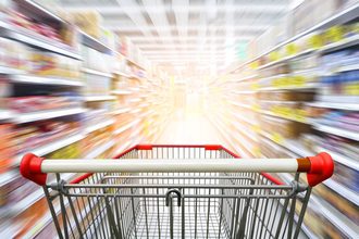 Supermarket aisle with empy shopping cart